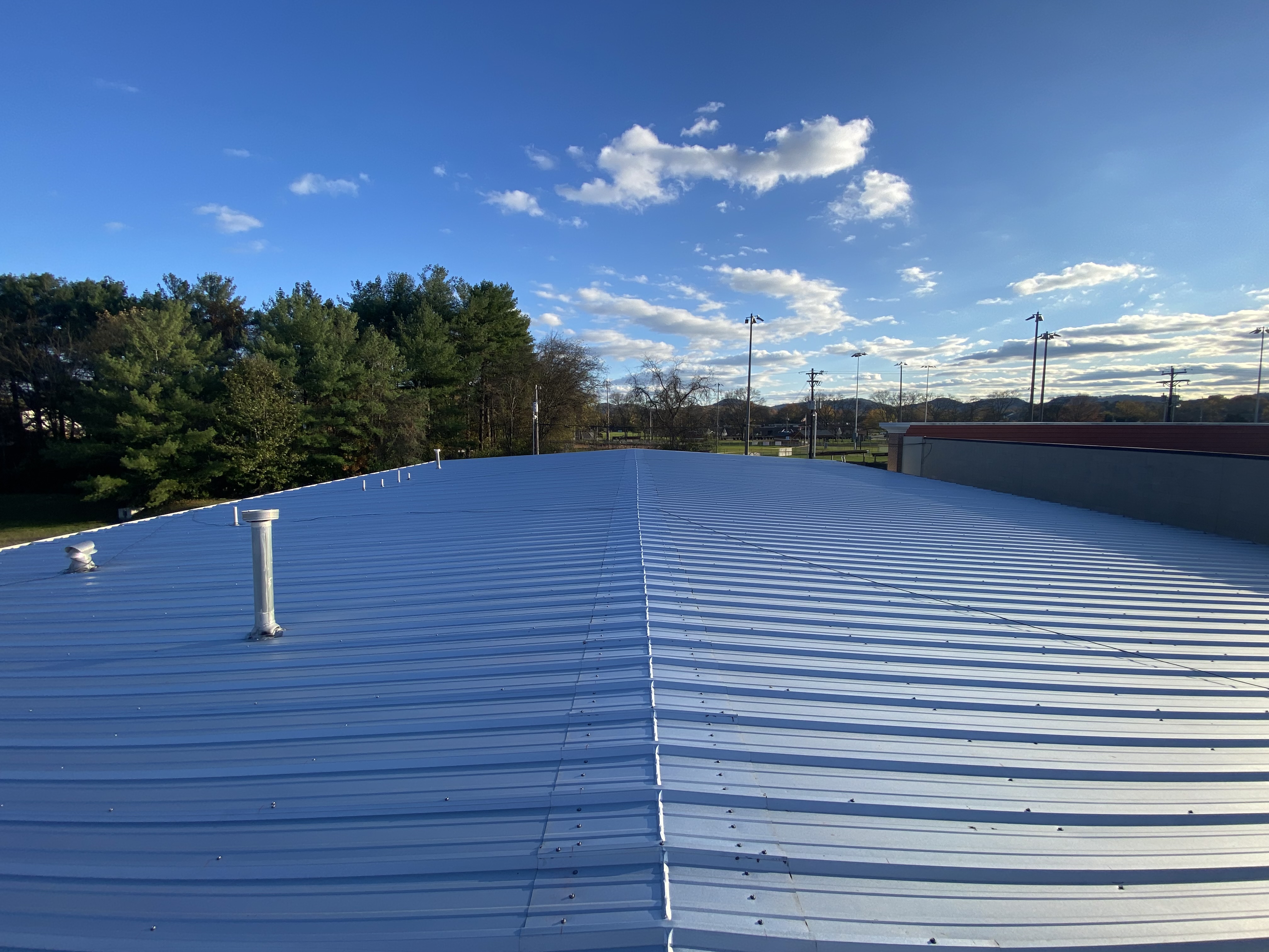 Commercial roof inspection in progress - drone-assisted aerial mapping paired with photo-keyed ground-level documentation